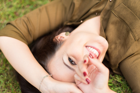 Smiling woman lying and relaxing in grassの写真素材