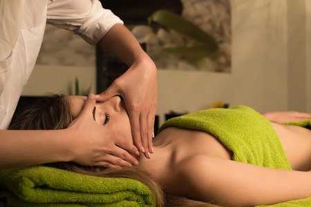 Woman doing face massage in spa clinicの写真素材
