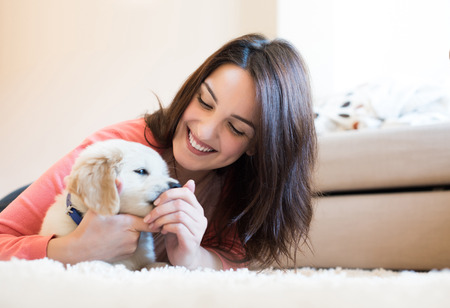 Woman lying on floor with a puppy
