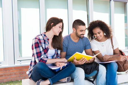Students sharing notes in the university campusの写真素材