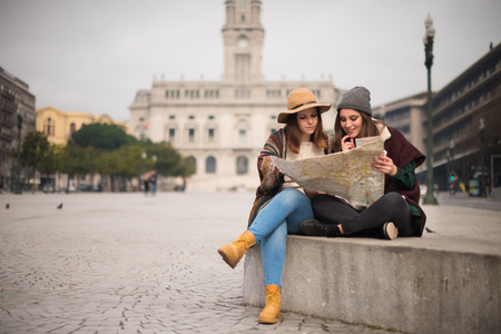 Female friends consulting a city map in the winterの写真素材