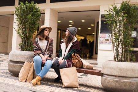 Couple od friends sitting on the city benchの写真素材