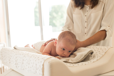 Mother changing a diaper on newborn babyの写真素材