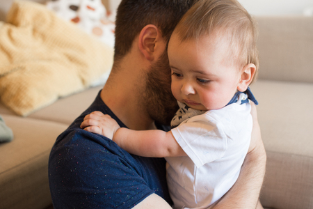 Young father taking care of crying babyの写真素材