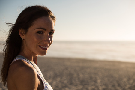 Portrait of woman enjoying beautiful sunset on the beachの写真素材