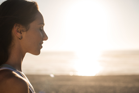 Portrait of woman enjoying beautiful sunset on the beachの写真素材