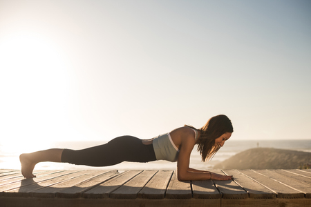 Women having a time doing pilates on the beachの写真素材