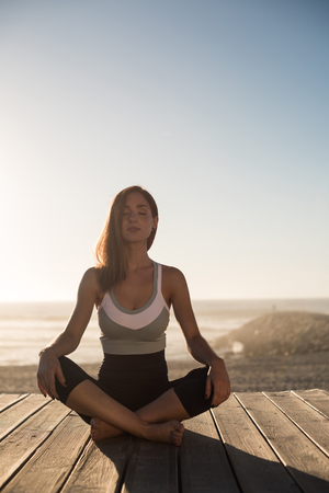 Women having a time meditating on the beachの写真素材
