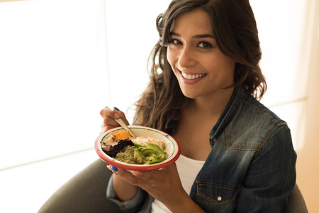 Woman eating a vegan bowl of superfoodsの写真素材