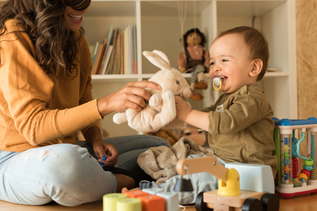 Young Mother playing with toddler at home の写真素材