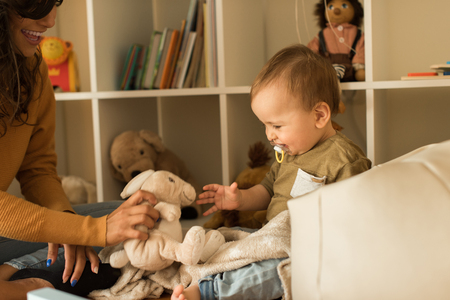 Young Mother playing with toddler at home の写真素材