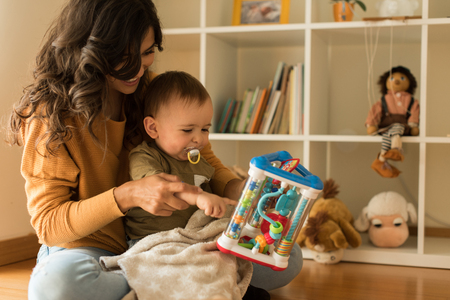 Young Mother playing with toddler at home の写真素材