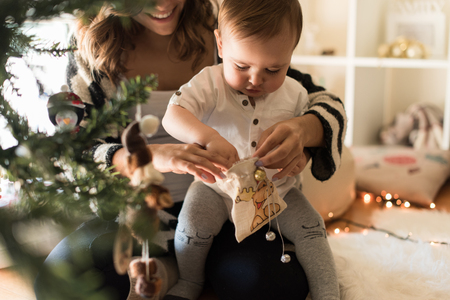 Mother and toddler decorating the Christmas tree.の写真素材