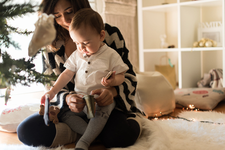 Mother and toddler decorating the Christmas tree.の写真素材