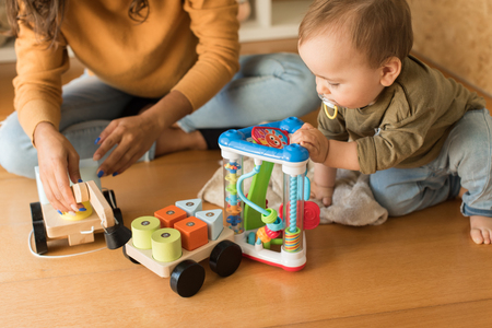 Young Mother playing with toddler at home の写真素材