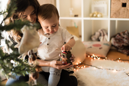 Mother and toddler decorating the Christmas tree.の写真素材