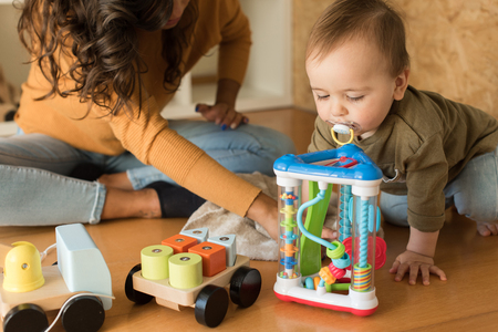 Young Mother playing with toddler at home の写真素材