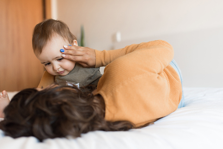 Young Mother playing with toddler at homeの写真素材