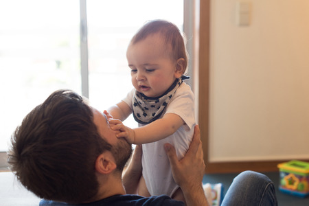 Modern father playing with little baby boyの写真素材