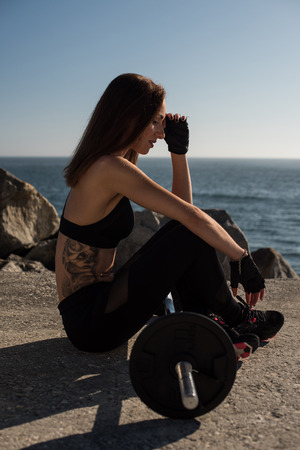 Fitness woman with tattoos lifting weights - Outdoorの写真素材