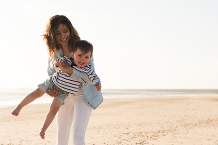 Young mother exploring the beach with toddlerの写真素材