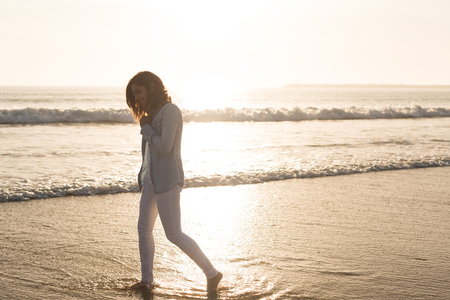Beautiful woman enjoying sunset at the beachの写真素材