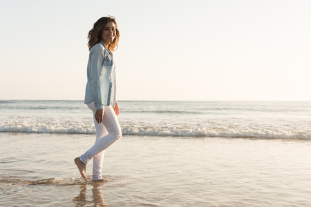 Beautiful woman enjoying sunset at the beachの写真素材