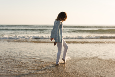 Beautiful woman enjoying sunset at the beachの写真素材
