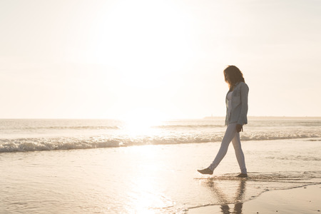 Beautiful woman enjoying sunset at the beachの写真素材