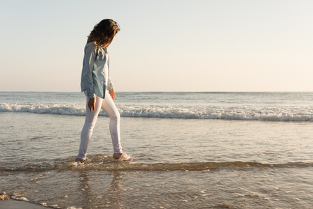 Beautiful woman enjoying sunset at the beachの写真素材