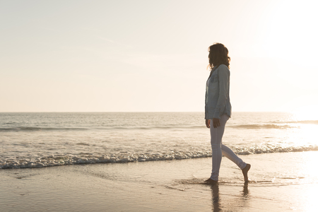 Beautiful woman enjoying sunset at the beachの写真素材
