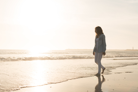 Beautiful woman enjoying sunset at the beachの写真素材