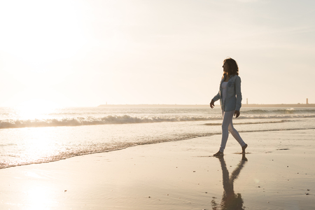 Beautiful woman enjoying sunset at the beachの写真素材