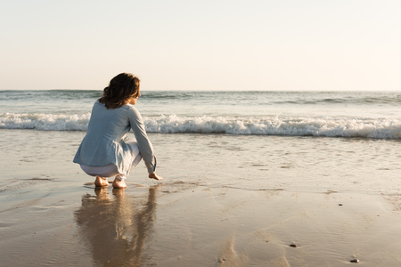 Beautiful woman enjoying sunset at the beachの写真素材