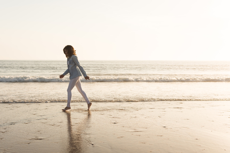 Beautiful woman enjoying sunset at the beachの写真素材
