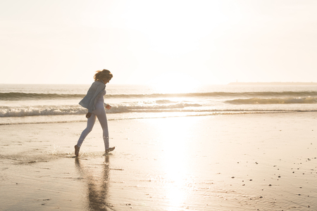 Beautiful woman enjoying sunset at the beachの写真素材