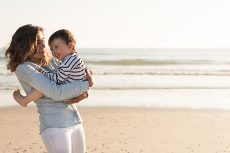 Young mother exploring the beach with toddlerの写真素材