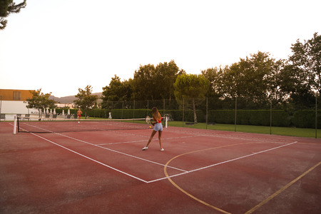 Couple playing tennis at the court - Natural sunset lightの写真素材