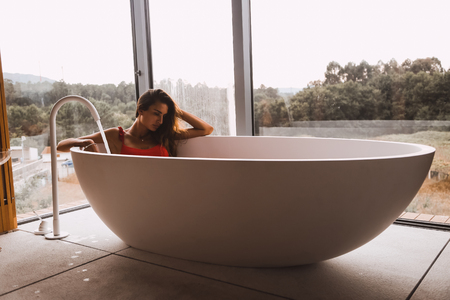 Woman bathing and relaxing in a modern bath tubの写真素材
