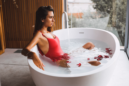 Woman bathing and relaxing in a modern bath tubの写真素材