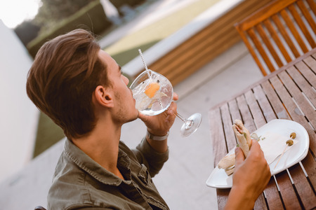 Man drinking cocktail and lunching near the poolの写真素材