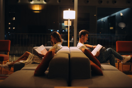 Man and woman reading books - Natural night lightの写真素材