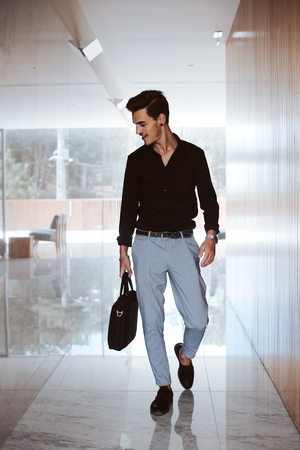 Casual business man walking inside office centerの写真素材