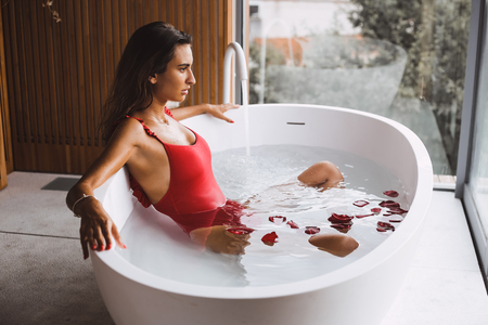 Woman bathing and relaxing in a modern bath tubの写真素材