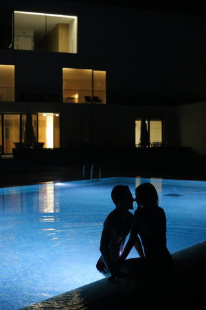 Romantic couple kissing at the pool in the night - Natural Lightの写真素材