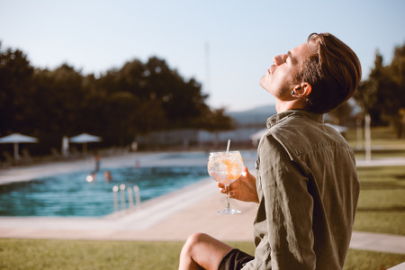 Man drinking cocktail near the pool - Spring and Summerの写真素材
