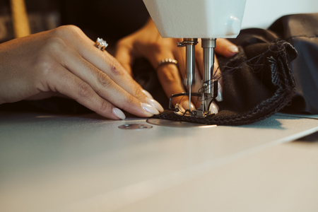 Close up of hands. Woman tailor working on sewing machine.の写真素材