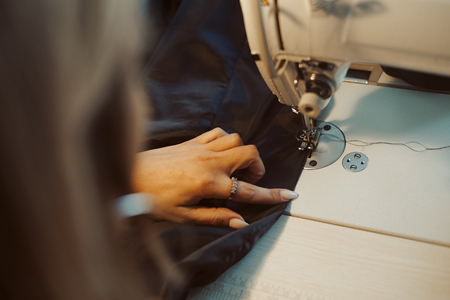 Close up of hands. Woman tailor working on sewing machine.の写真素材