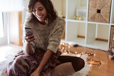 Woman texting in a smartphone - Christmas and Winter Seasonの写真素材