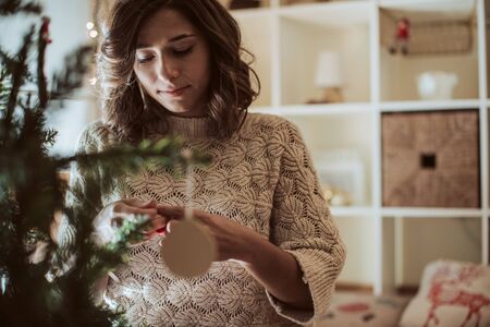 Woman decorating Christmas Tree at home - Winter Seasonの写真素材